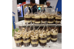Chocolate layered desserts in a cups displayed on a table.